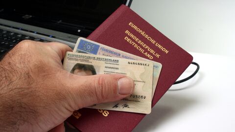 Mann hält Personalausweis, Führerschein und Reisepass in der Hand Mann hält Personalausweis, Führerschein und Reisepass in der Hand
