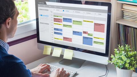 Ein Mann schaut in seinen Kalender im E-Mail Programm Ein Mann schaut in seinen Kalender im E-Mail Programm
