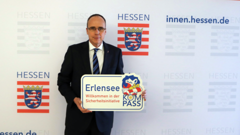 Innenminister Peter Beuth hält ein KOMPASS-Schild für Erlensee Innenminister Peter Beuth hält ein KOMPASS-Schild für Erlensee