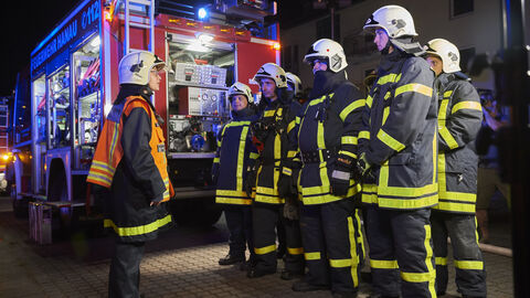 Feuerwehrleute besprechen sich beim Einsatz Feuerwehrleute besprechen sich beim Einsatz