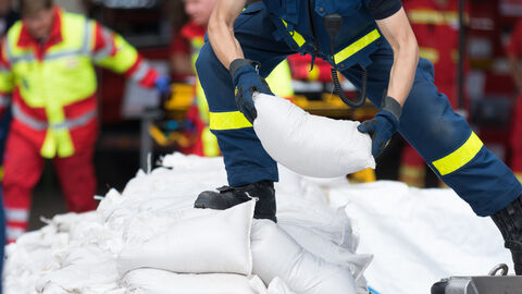 Helfer transportiert Sandsäcke Helfer transportiert Sandsäcke