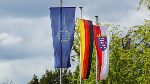Flagge von der Europäischen Union, Deutschland und dem Bundesland Hessen, die an einer Fahnenstange hängen Flagge von der Europäischen Union, Deutschland und dem Bundesland Hessen, die an einer Fahnenstange hängen