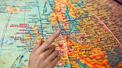 Finger zeigt auf einen Globus Finger zeigt auf einen Globus