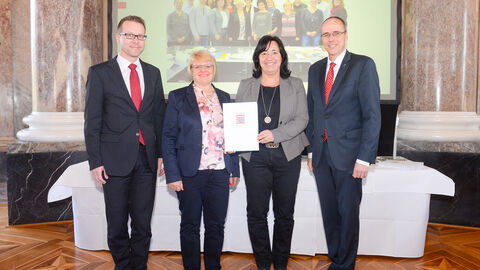 Finanzamt Gelnhausen Finanzamt Gelnhausen - Familienfreundlicher Arbeitgeber Land Hessen Verleihung 2019 - vier Personen halten lächelnd eine Urkunde in die Kamera