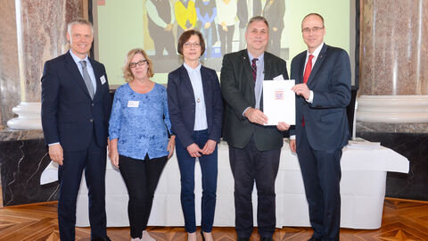 Hessische Lehrkräfteakademie - Standort Wiesbaden Hessische Lehrkräfteakademie - Standort Wiesbaden - Familienfreundlicher Arbeitgeber Land Hessen Verleihung 2019 - fünf Personen halten lächelnd eine Urkunde in die Kamera