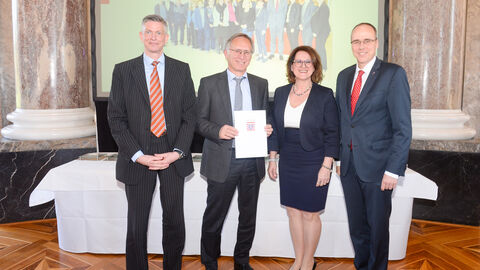 Hessisches Ministerium des Innern und für Sport Hessisches Ministerium des Innern und für Sport - Familienfreundlicher Arbeitgeber Land Hessen Verleihung 2019 - vier Personen halten lächelnd eine Urkunde in die Kamera