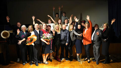 Beteiligte des Theaterstücks nach der Premiere mit Blumen.