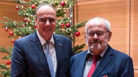 Innenminister Peter Beuth und Franz Horne schauen mit der Auszeichnung in der Hand in die Kamera