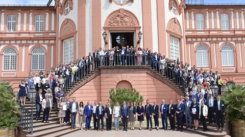 Alle Beteiligten bei der Verleihung der Gütesiegel stehen auf den Stufen verteilt auf der Treppe des Schloss Biebrich