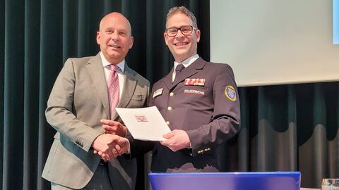 Innenminister Roman Poseck auf Landesfeuerwehrmusikversammlung Innenminister Roman Poseck mit Alexander Eckhardt, Landesstabführer und Mitglied im Präsidium Landesfeuerwehrverband auf Bühne