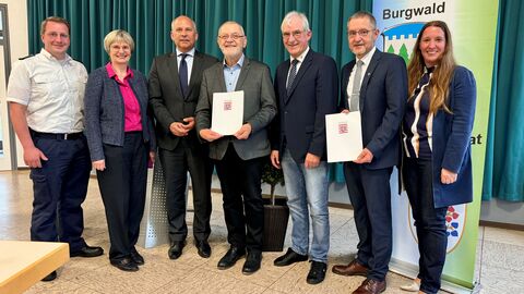 Gemeindebrandinspektor Mark Engel, Landtagsabgeordnete Claudia Ravensburg, Innenminister Roman Poseck, Vorsitzender der Partnerschaftsvereinigung Adam Daume, Erster Kreisbeigeordneter Karl-Friedrich Frese, Bürgermeister Lothar Koch, Landtagsabgeordnete Daniela Sommer vor grünem Vorhang