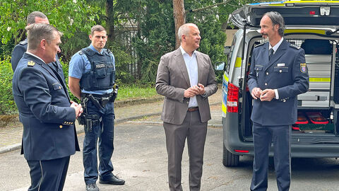 Innenminister Roman Poseck, HPT-Präsident Frank von der Au, Polizeihauptkommissar Thomas Rudersdorf, Leiter der Fahrzeugkonzeption im Austausch mit Bediensteten