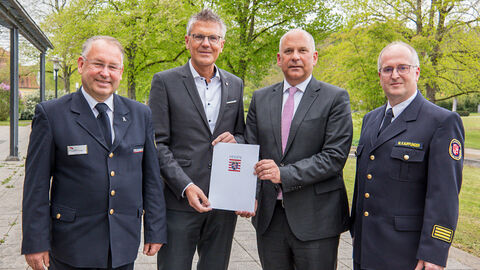 Innenminister Roman Poseck mit dem Ersten Kreisbeigeordneten des Landkreises Hersfeld-Rotenburg Dirk Noll und weiteren Personen bei der Übergabe des Förderbescheids.