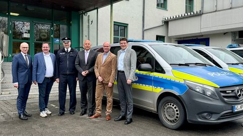 Landespolizeipräsident Robert Schäfer, MdL Frank Steinraths, Dienststellenleiter Michael Pagel, Innenminister Roman Poseck, Stadtrat Jörg Kratkey und Bürgermeister Andreas Viertelhausen stehen vor einem Polizeigebäude und neben einem Polizeiwagen zum Gruppenfoto aufgestellt.