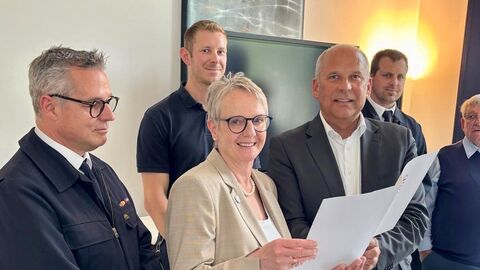 Innenminister Roman Poseck übergibt Birgit Kannegießer, Bürgermeisterin der Gemeinde Seeheim-Jugenheim, einen Zuwendungsbescheid für ein neues Feuerwehrfahrzeug 