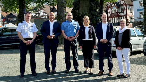 Innenminister Poseck steht mit mereren Personen auf einem Platz zum Gruppenfoto aufgestellt.