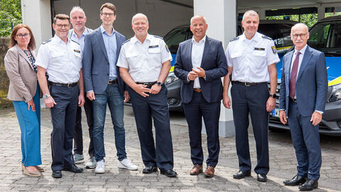 Innenminister Poseck steht mit weiteren Personen der Polizei vor einem Gebäude