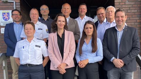 Innenminister Poseck steht mit Vertretern der Polizeistation Schwalmstadt vor dem Gebäude auf den Treppen. Sie sind zum Gruppenfoto aufgestellt.