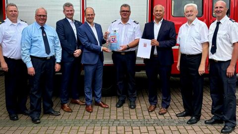 Innenminister Roman Poseck steht u.a. mit Bürgermeister Eitz, Kreisbeigeordneten Andreas Hofmann, Gemeindevertreter Hugo Klein und Kreisbrandinspektor Harald Hellenbrandt zusammen vor einem Feuerwehrfahrzeug.