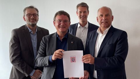 : v.l. Erik Schmekel (kommissarischer Fachbereichsleiter Soziales), Bürgermeister Dirk Gene Hagelstein, Thorsten Klees (stellvertretender Stadtverordnetenvorsteher, CDU) sowie Innenminister Prof. Dr. Roman Poseck stehen zusammen und halten den Förderbescheid in die Kamera.
