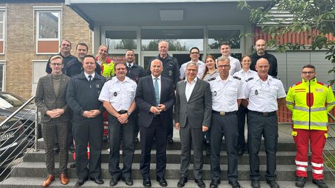 Innenminister Roman Poseck unter anderem mit Oberbürgermeister Gert-Uwe Mende, Amtsleiter Andreas Kleber und Angehörigen der Freiwilligen Feuerwehr, der Berufsfeuerwehr sowie des Rettungsdienstes
