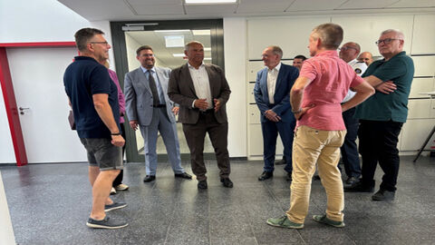 Innenminister Poseck steht zusammen mit Mitgliedern der Freiwilligen Feuerwehr Walldorf 