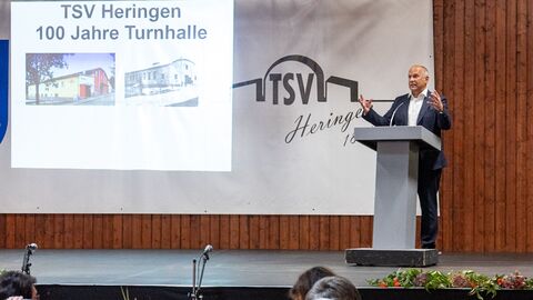 Innenminister Roman Poseck steht vor einem Pult und spricht zum Publikum.