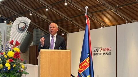 Innenminister Poseck steht an einem Rednerpult, dahinter ein Aufsteller des Feuerwehrverbandes sowie einer der "Stadtwerke Frankfurt am Main".