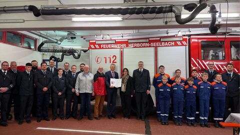 Mehrere Personen stehen vor Feuerwehrauto