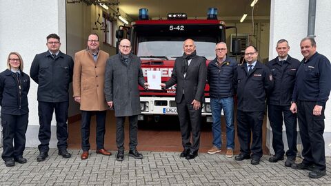 Mehrere Personen stehen vor EInsatzfahrzeug