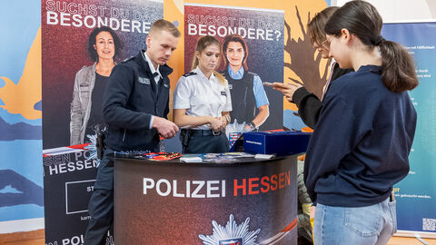 Cops im Dialog Ein Mädchen lässt sich von einem Polizisten und einer Polizistin an einem Stand beraten.