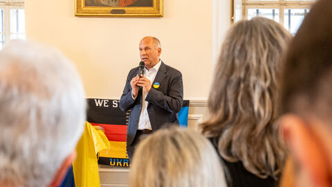 Mann mit Mikrofon spricht zu Publikum