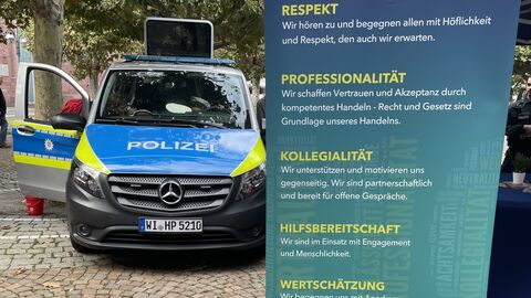 Polizeiwagen neben einem Plakat