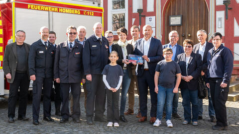 Gruppenfoto vor einem Feuerwehrfahrzeug.