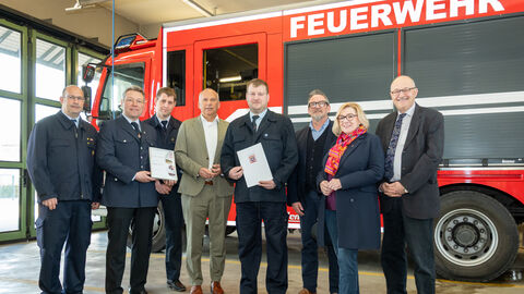 Mehrere Männer vor Feuerwehrauto