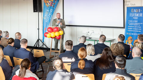 Innenminister Poseck steht auf Bühne und hält eine Rede vor Publikum.