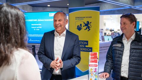 Innenminister Poseck im Gespräch an einem Messestand.