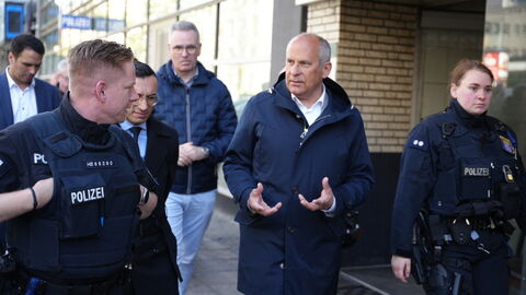 Innenminister Poseck spricht mit Polizisten.