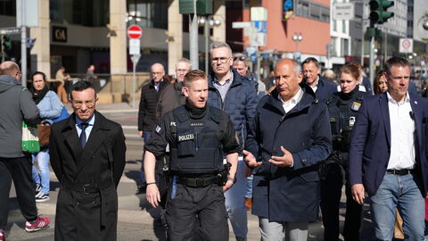 Innenminister Poseck läuft mit einer größeren Gruppe durch eine Stadt.