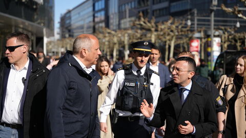 Eine Gruppe um Innenminister Poseck bewegt sich durch eine Stadt.
