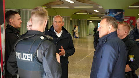 In einer U-Bahn-Station spricht Innenminister Poseck mit Polizistinnen und Polizisten.