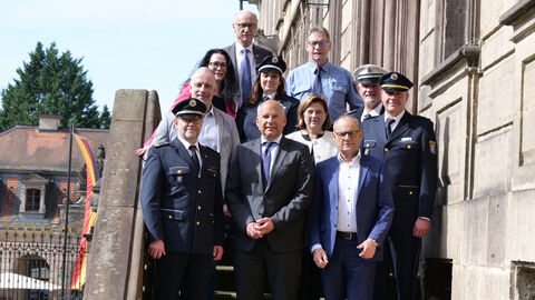Innenminister Poseck steht mit einer Gruppe durch auf den Treppenstufen des Stadtschlosses.