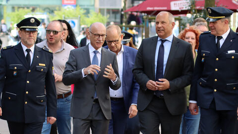 Innenminister Poseck läuft mit einer größeren Gruppe durch eine Stadt.