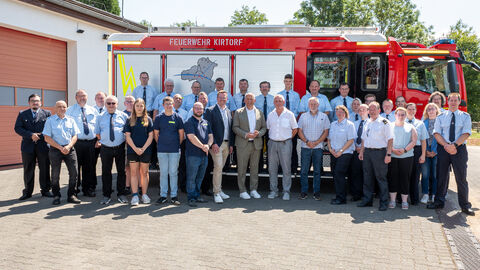 Viele Personen stehen vor Feuerwehrauto