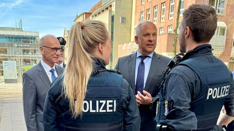 Innenminister Poseck im Gespräch mit einem Polizisten und einer Polizistin