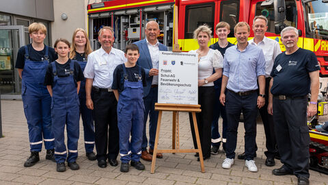 Heimatschutzminister Roman Poseck u. a. mit Schulleiterin Uta Stitterich und dem Präsidenten des Landesfeuerwehverbandes Hessen, Norbert Fischer