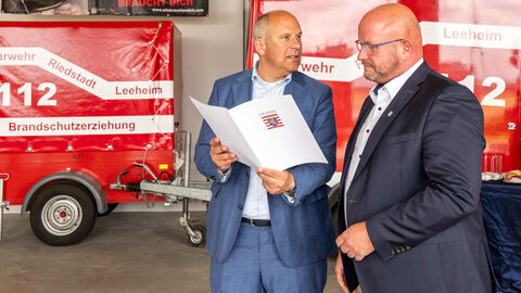 Zwei Männer stehen vor Feuerwehrauto