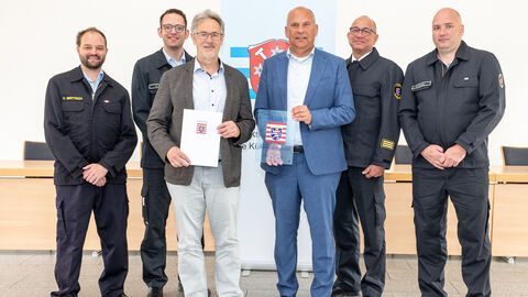 Heimatschutzminister Roman Poseck überreicht Bürgermeister Thomas Raschel den Zuwendungsbescheid