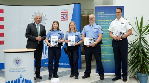 Innenminister Poseck steht mit Polizeibeamten und dem Polizeipräsidenten bei der Vorstellung der neuen Dienstausweise zusammen.