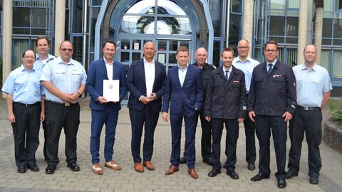 Roman Poseck u. a. mit Bürgermeister Joachim Reimann, dem Landtagsabgeordneten André Stolz und Vertretern der Freiwilligen Feuerwehren Seitzenhahn und Wehen bei der Bescheidübergabe.